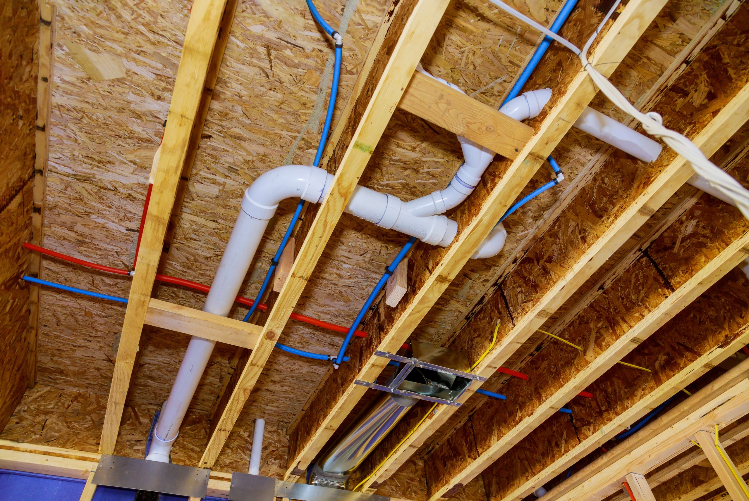 home construction with hot and cold blue and red pex pipe layout in pipes and exposed beams